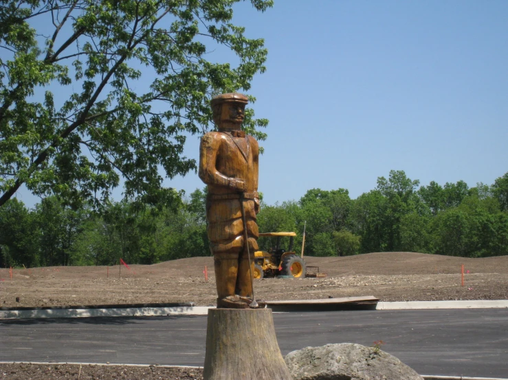 a wood statue in the shape of a man in a construction zone