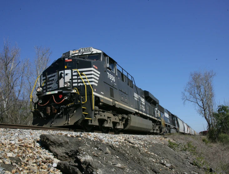 a black train is traveling on the railroad tracks