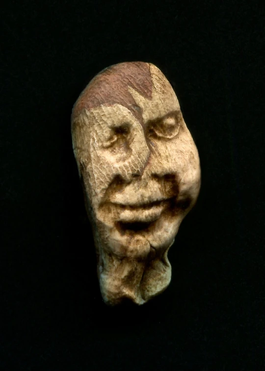 a wooden mask with a frowned face has eyes open