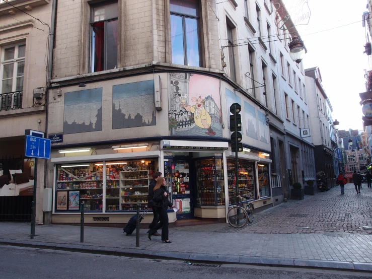 two men walk past a multi - story building on a street corner