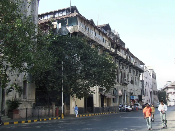 a street with a group of people walking next to trees