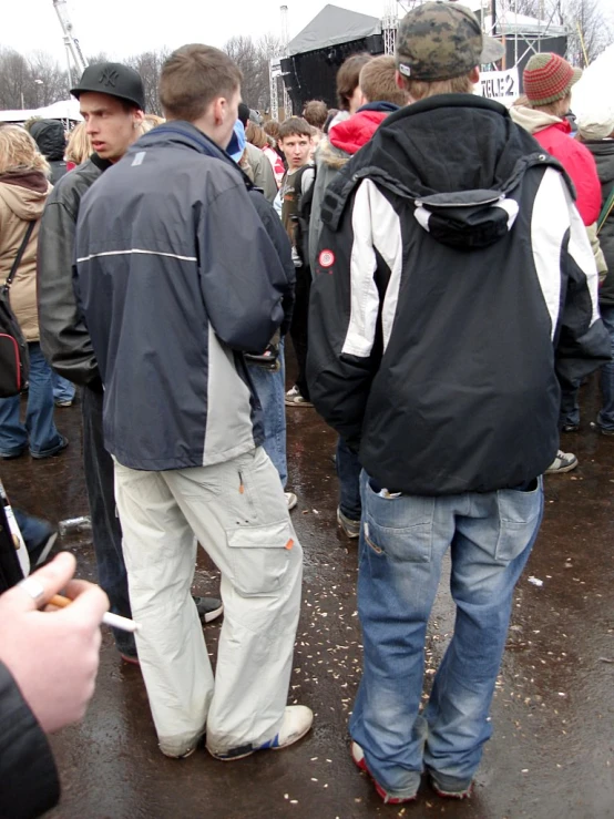 group of people standing near the road with backpacks