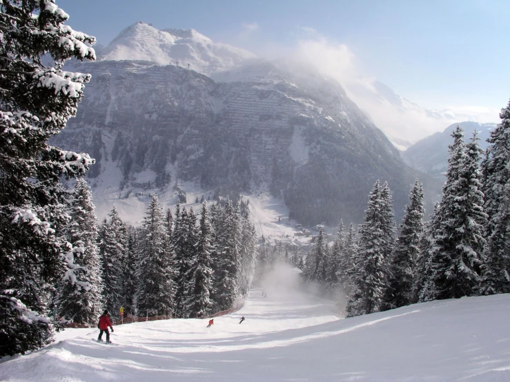 a group of people snowboarding and skiing in the mountains