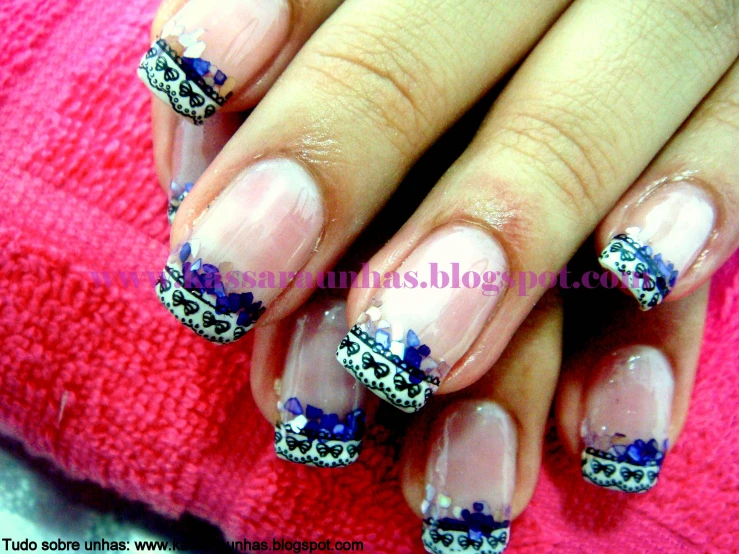 a woman's nails with blue flowers and lace