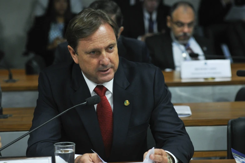 a man sitting at a desk in front of a microphone