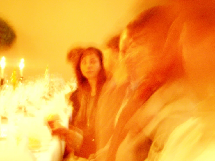 blurry pograph of group of people sitting at dinner table