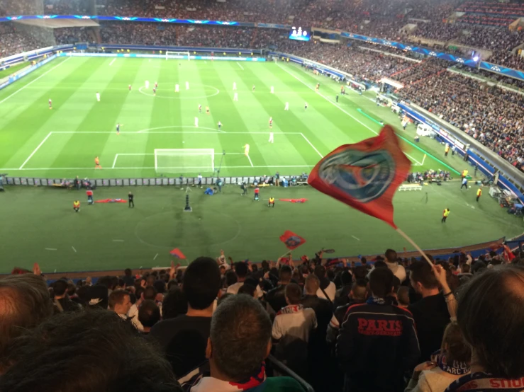 an audience is watching a soccer match at night