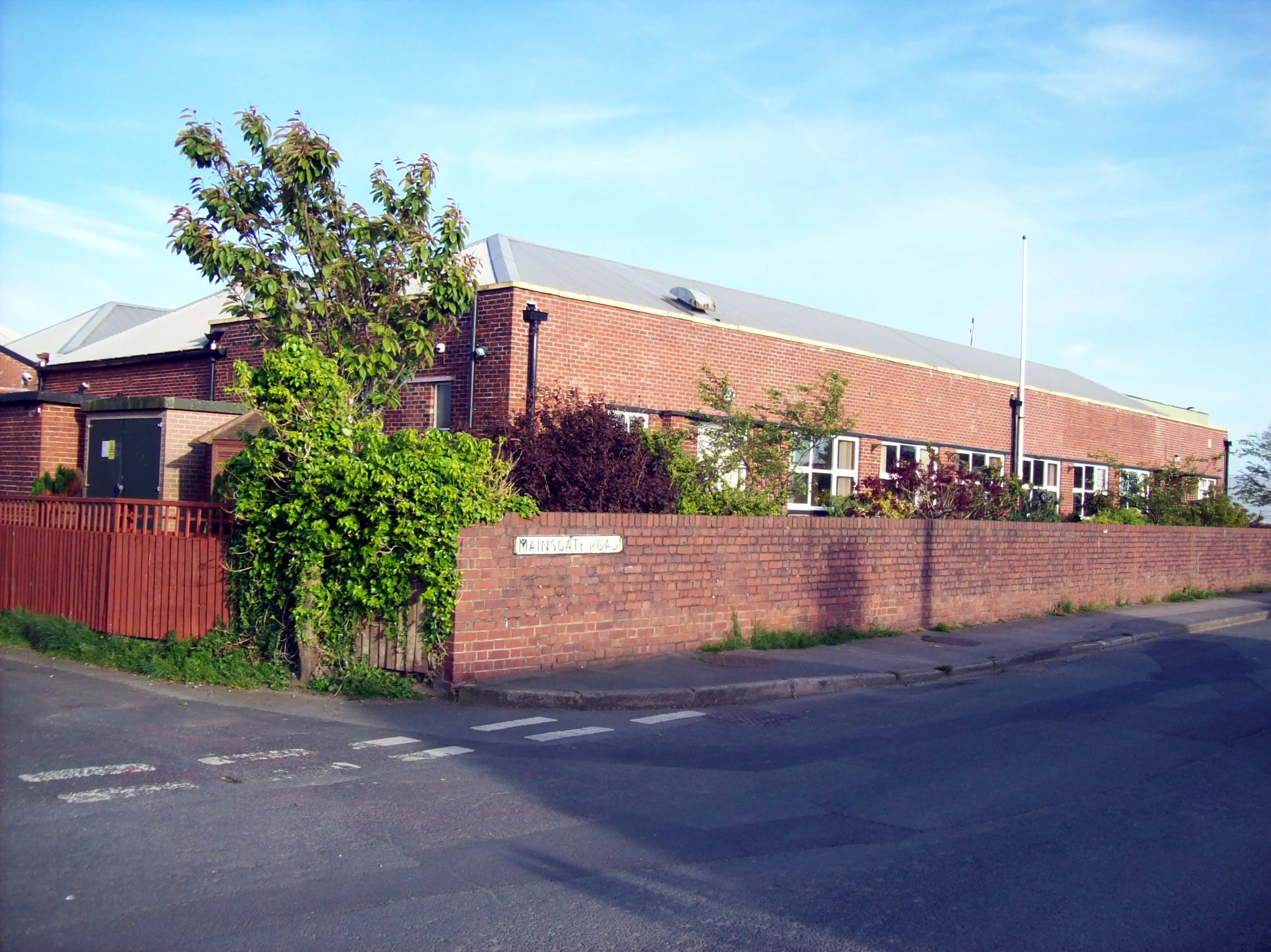 a brick building on the corner of a quiet street