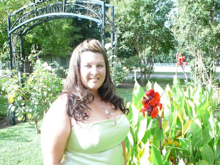 woman in white dress standing by lush green plants