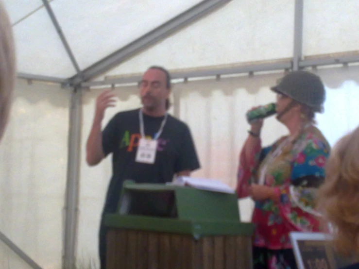 man speaking into microphone standing next to woman at outdoor event