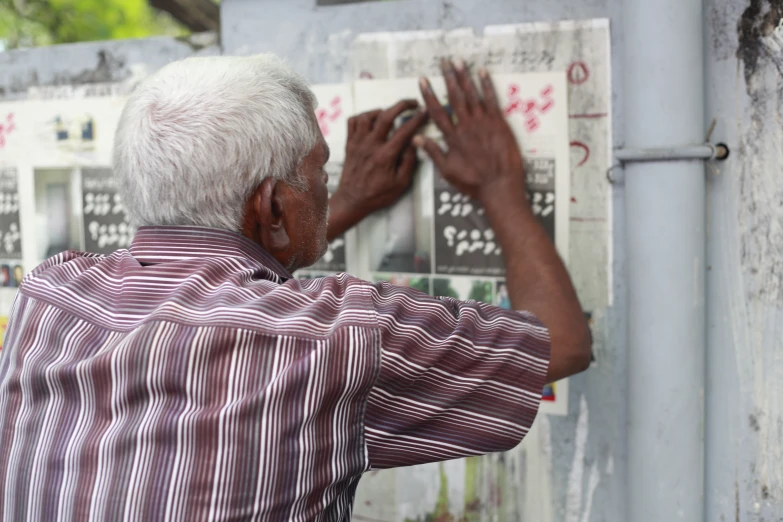 a man writing on a white and black poster