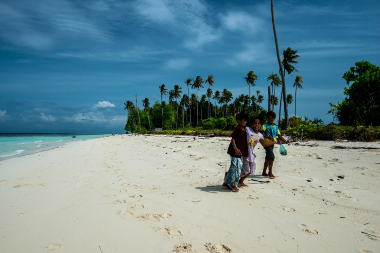 two people standing on a beach with a blue ocean