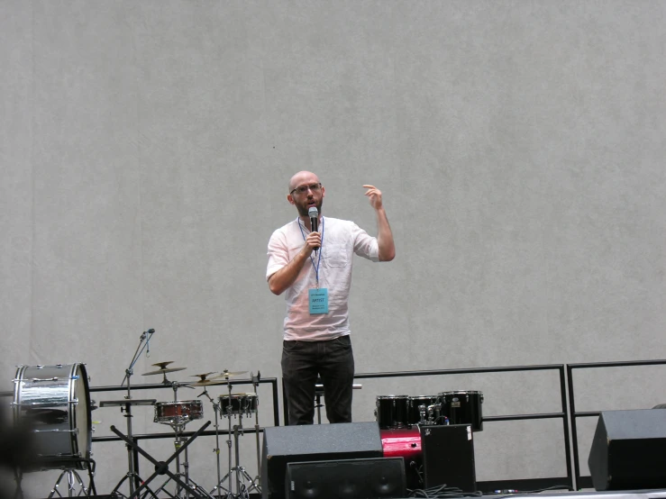 the man is speaking into a microphone while holding up his right hand