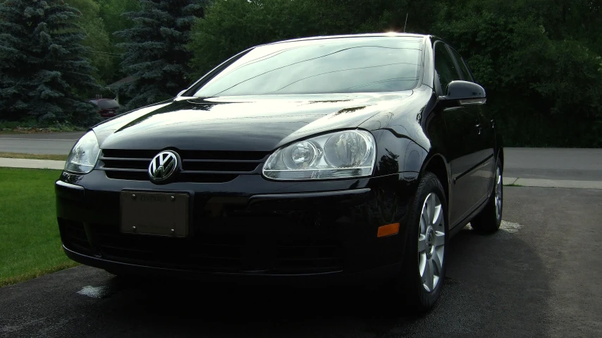 a black volkswagen golf is parked in the driveway