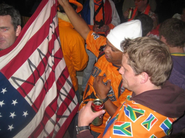 a group of people hold up large and small flags