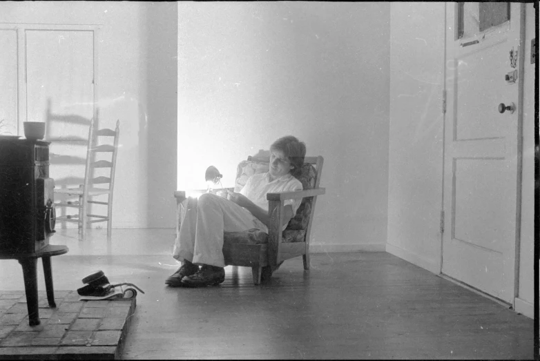 an old man sits in a chair near a doorway