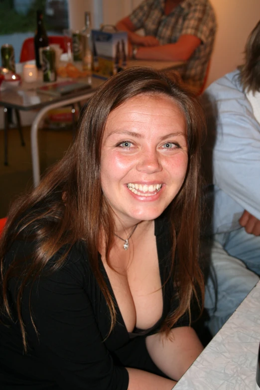 the young woman is sitting and smiling at the camera