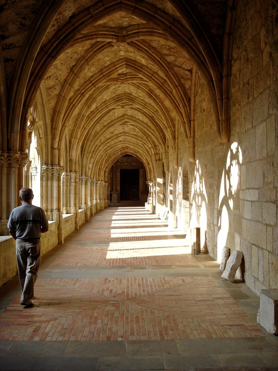 there is a man walking down a long hall