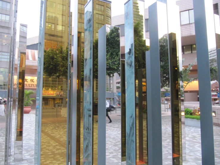 a man walking past tall glass buildings on the sidewalk