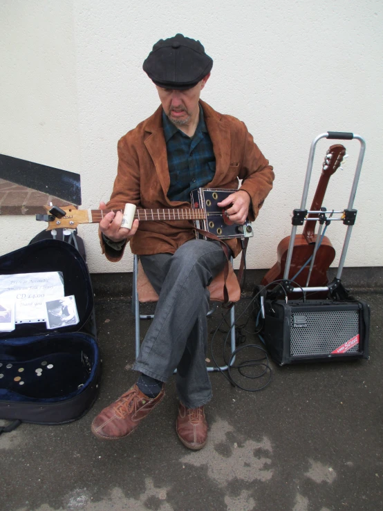 the man is playing an acoustic guitar near some luggage