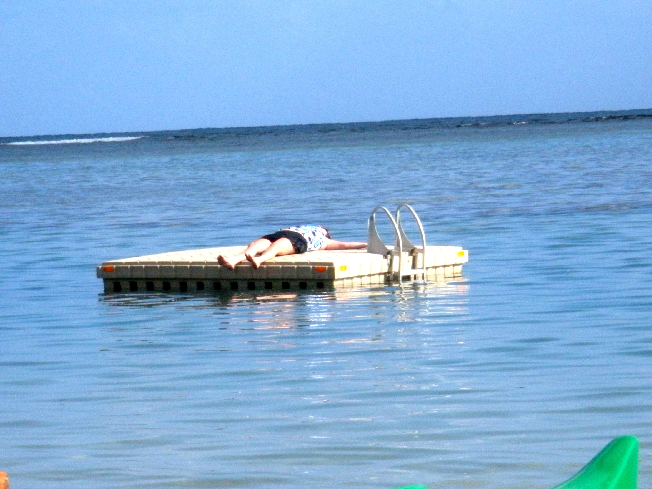 a person lying down on the beach on a dock