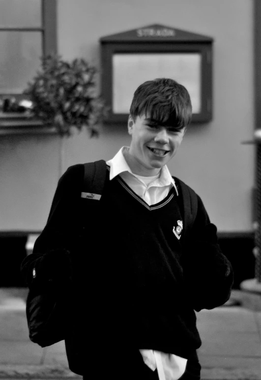 a young man is smiling while standing on a city street