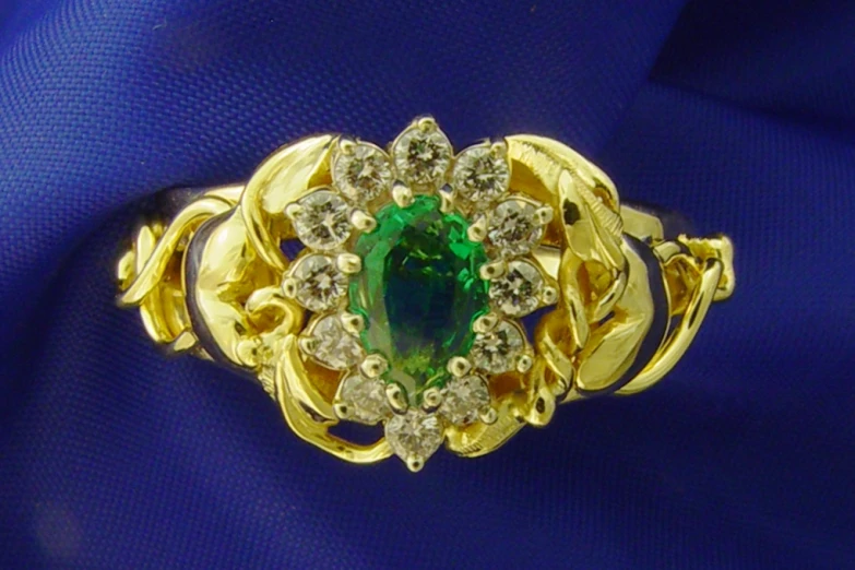 an intricate ring that has a green and white stone set in gold