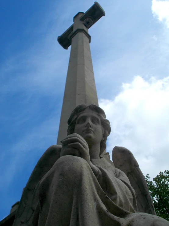 an angel sculpture is in front of a monument