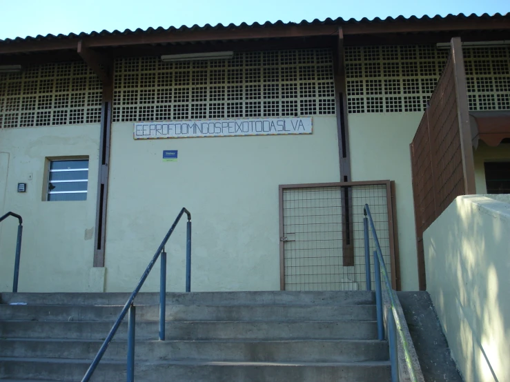 steps leading to a building with a metal fence and entrance