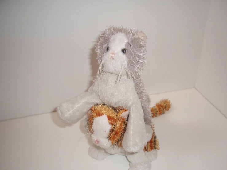 small stuffed toy sitting in corner holding item