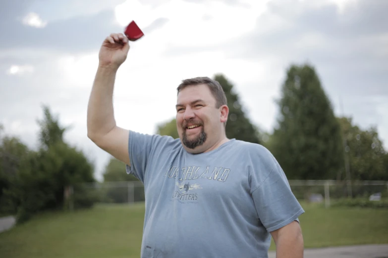 a man stands holding up a paper kite