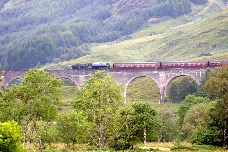 a long train crossing a bridge over water