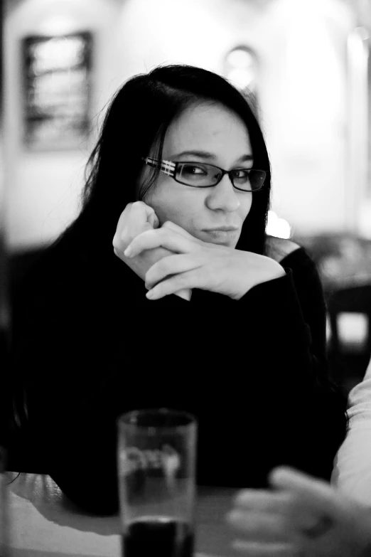 a woman with black hair sitting at a table