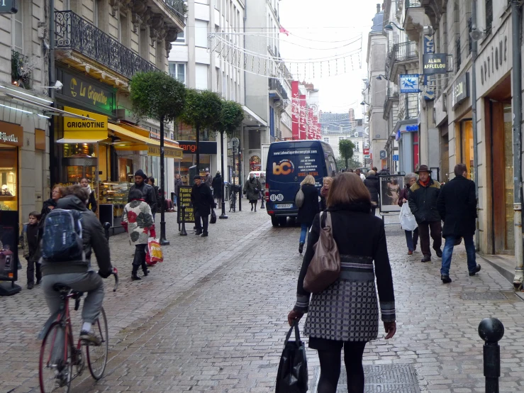 a woman with a brown purse is standing on a busy street in a city