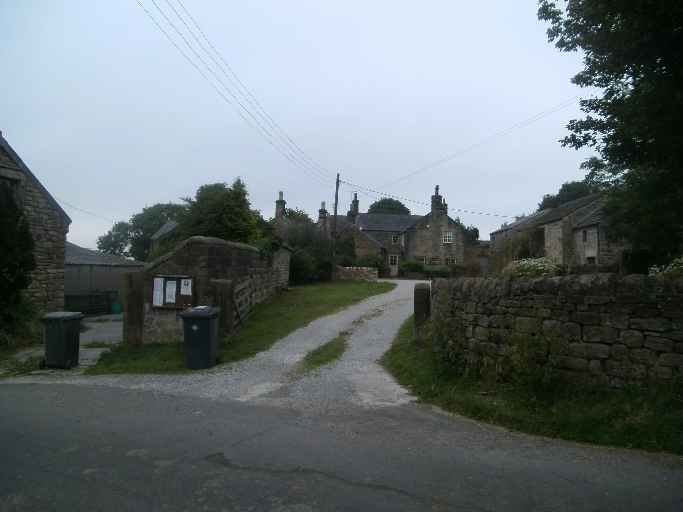 a quiet country road is paved and lined with stone houses