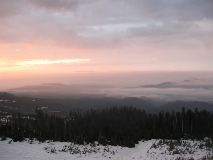 a mountain in the evening with a foggy valley