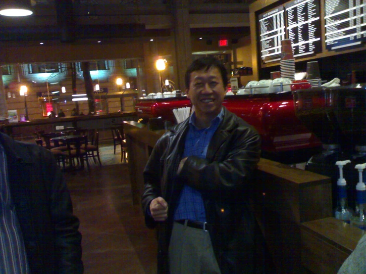 two men pose for the camera in a large restaurant