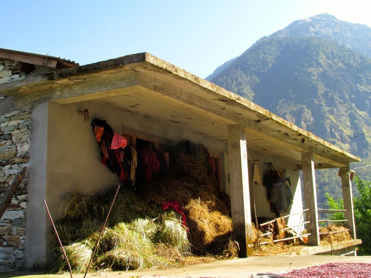 a house with clothing hanging on a rack in the middle of mountains