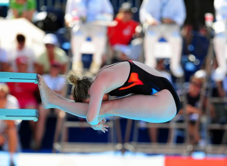 a woman on a diving board dives into the water