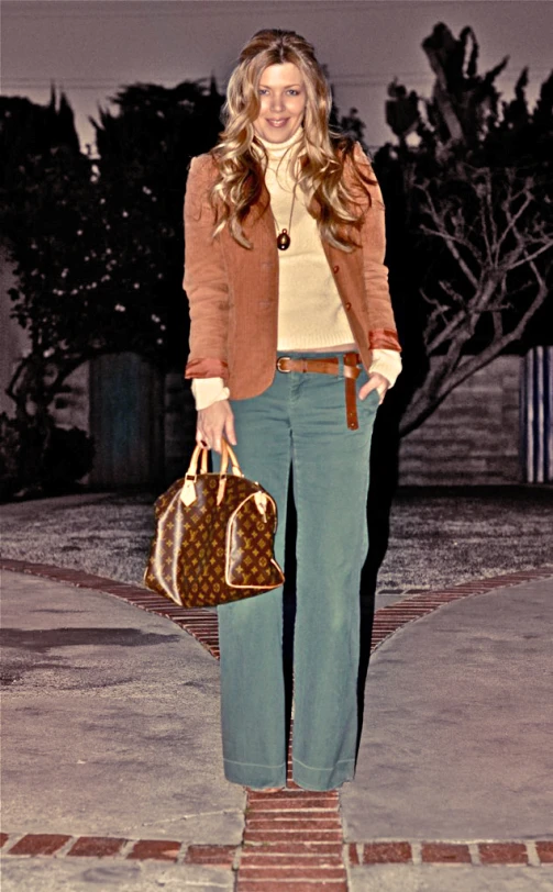 a model carrying two handbags and wearing a coat