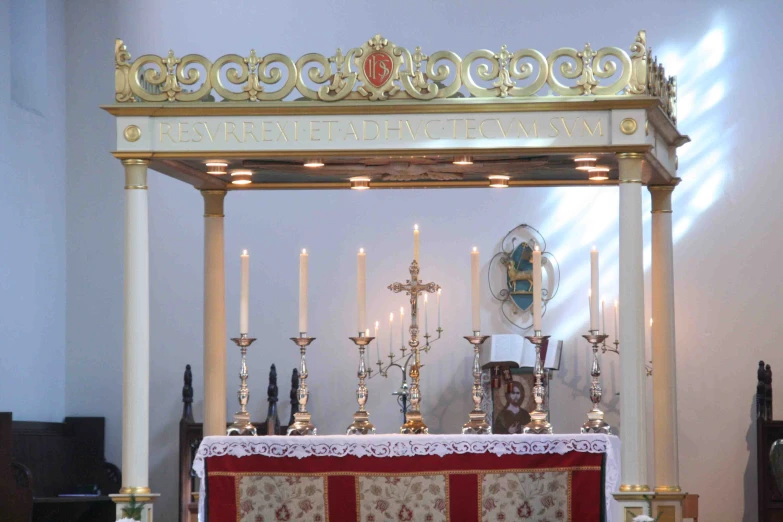 the alter has many silver and gold altars with a red rug