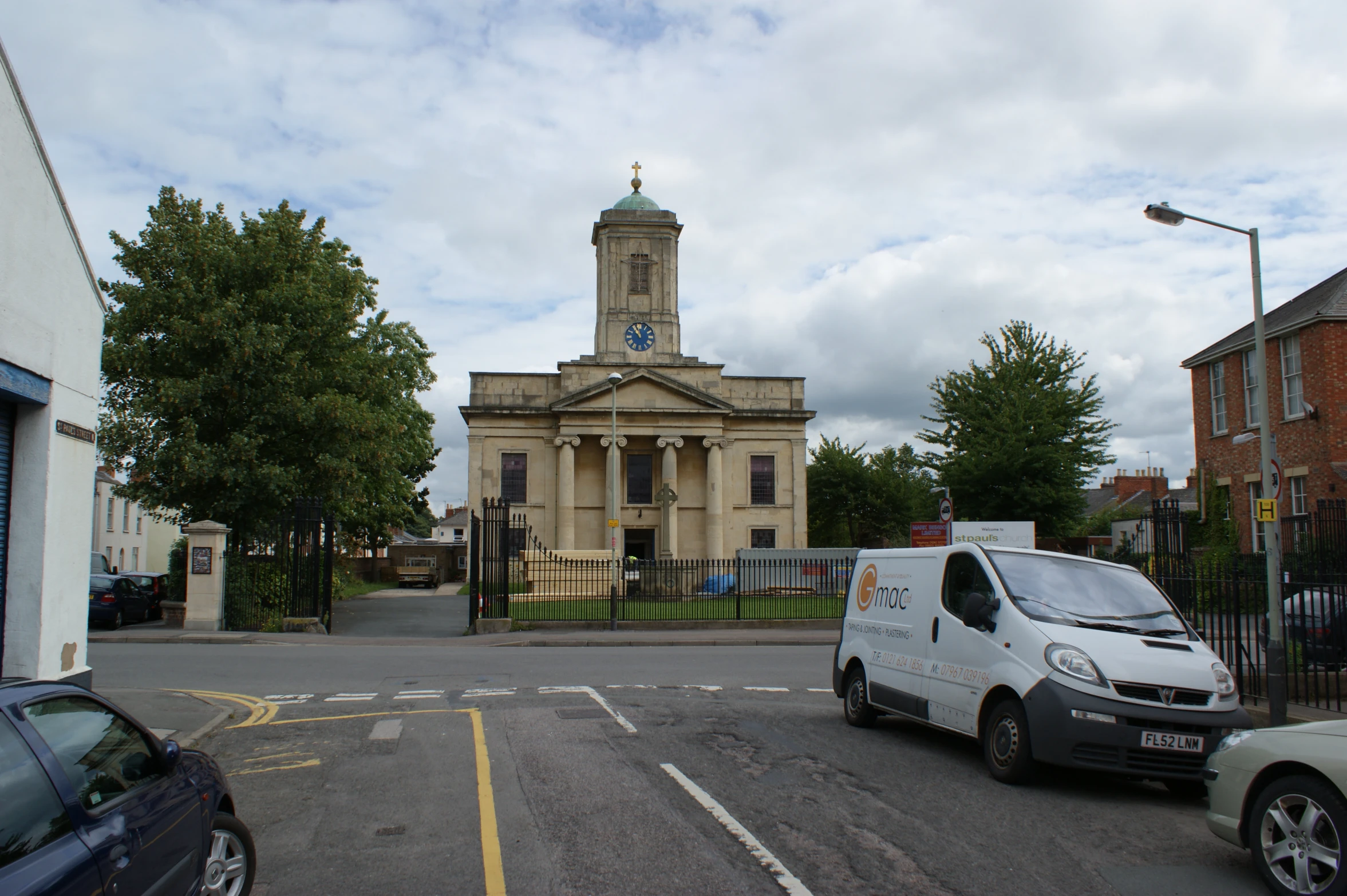 the small truck is driving towards the tall church