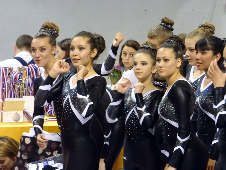 group of girls with uniforms on holding up their hands