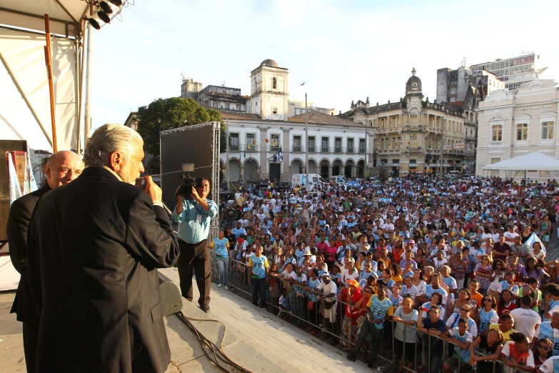 two men speaking to the crowd at an event