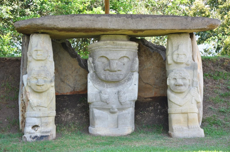 statues of faces surround each other around a round stone structure