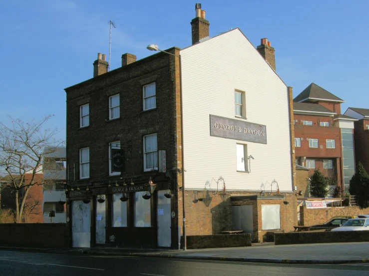 the corner building has several windows with white paint