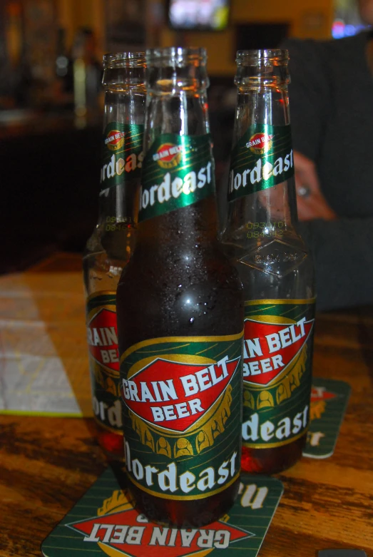 three bottles on a table with green and yellow labels