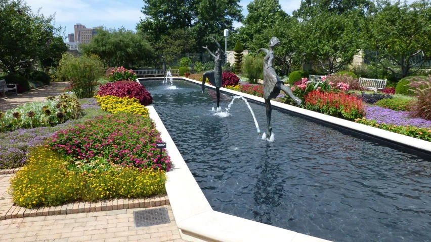 several water spouts running across a pond surrounded by trees