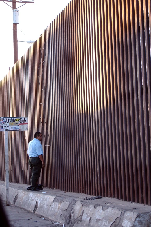 a man is leaning against a wall outside