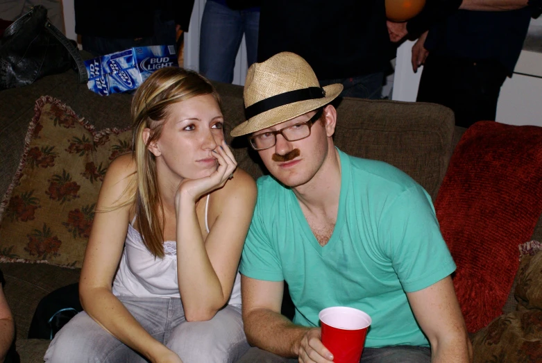 a girl and a guy are sitting together on a couch